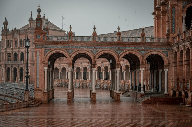 Elegant arches of Plaza de España in Seville, Spain captured during a serene rainy day.