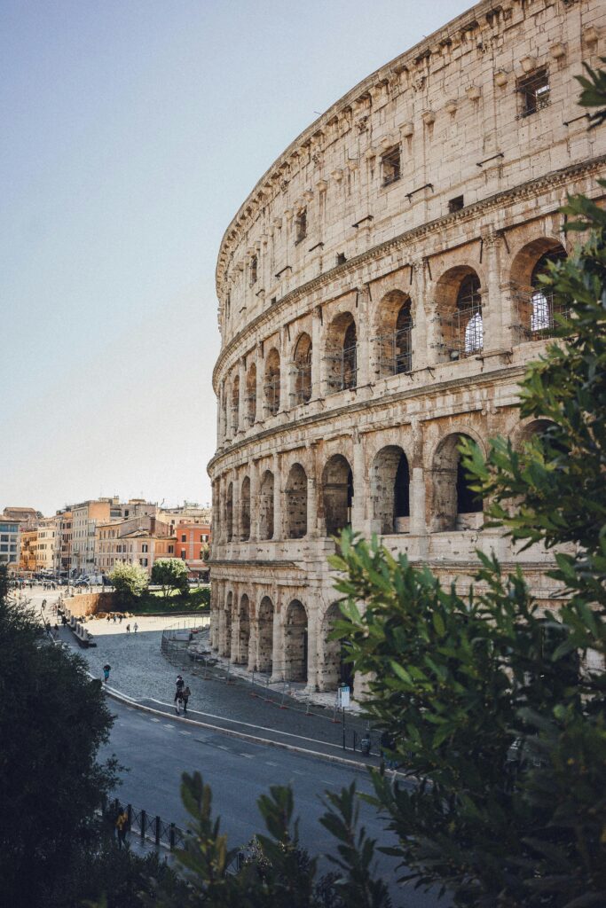 A stunning view of the Colosseum in Rome with surrounding urban landscape on a sunny day.